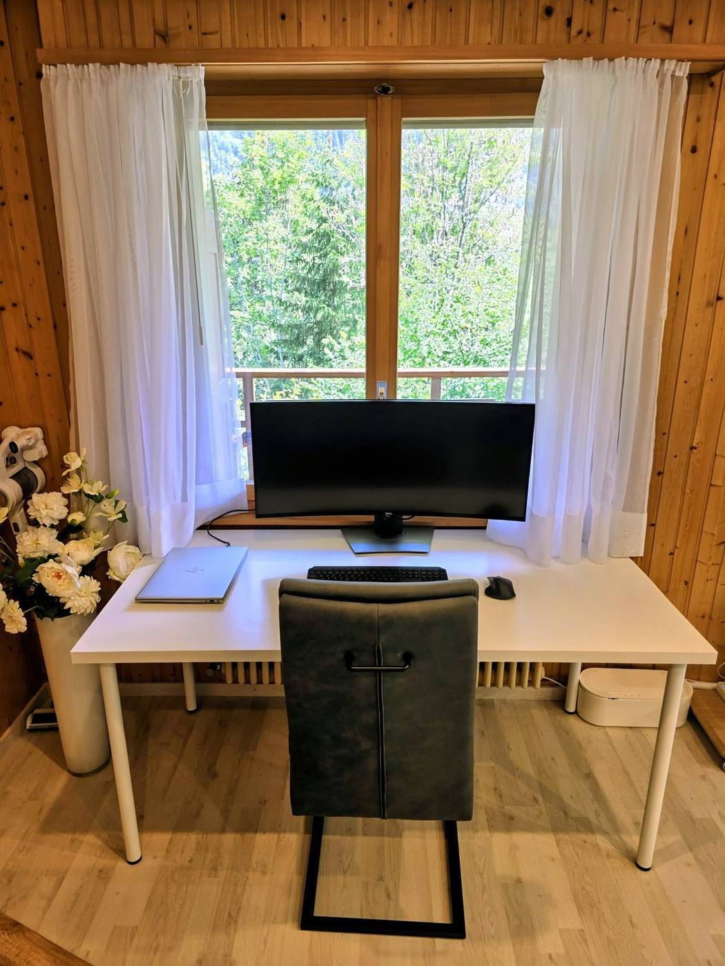 Arbeitsplatz mit Ultrawide-Monitor und Blick in den Wald